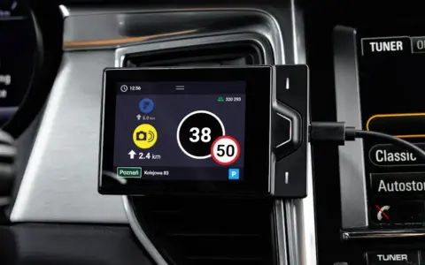 Nawigacja w pojeździe kategorii M1 pokazuje aktualną prędkość 38 km/h i ograniczenie do 50 km/h.