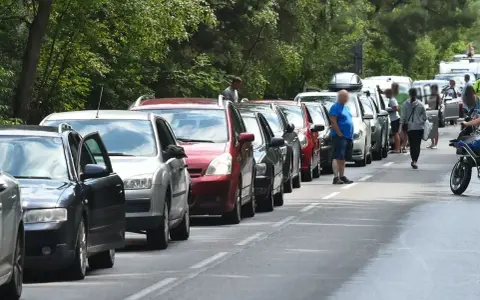 Długi korek samochodów na trasie do Helu. Kierowcy stoją w upale, czekając na przejazd.