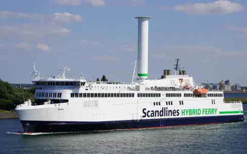 Prom na trasie Rostock-Gedser, "Berlin", z charakterystycznym, wysokim kominem i zielonym napisem "Scandlines HYBRID FERRY", płynie po wodzie.
