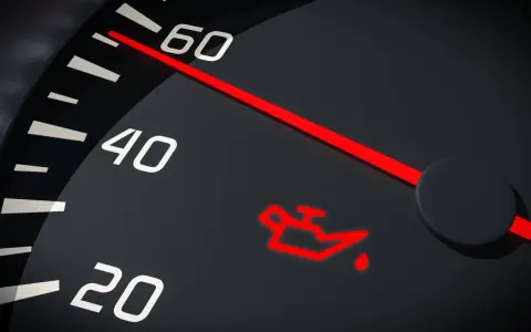 Czerwona kontrolka niskiego poziomu oleju na desce rozdzielczej. Wskaźnik pokazuje niski stan płynu.