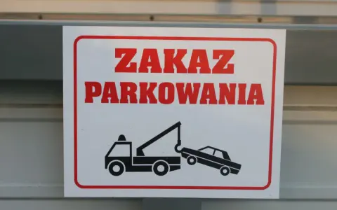 Zasady parkowania na parkingu: zakaz parkowania, holowanie pojazdów. Znak ostrzega przed odholowaniem źle zaparkowanego auta.