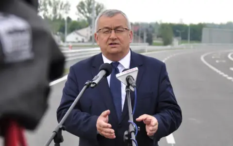 Mężczyzna w garniturze przemawia do mikrofonów na tle nowej drogi, która połączy Lublin i Rzeszów.