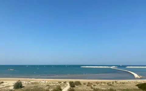 Piękny dzień nad morzem w Pescara i okolice. Wiele żaglówek na turkusowej wodzie, piaszczysta plaża i falochrony.