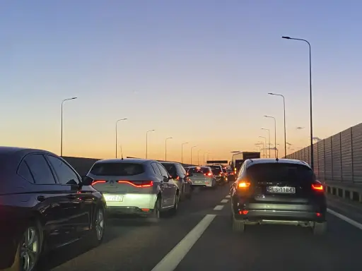 Korek na trasie Kraków - Poznań jak najszybciej. Samochody stoją na autostradzie o zachodzie słońca.