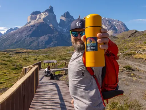 Mężczyzna z żółtym termosem na tle majestatycznych gór. To z pewnością Patagonia, a nie Alzacja.