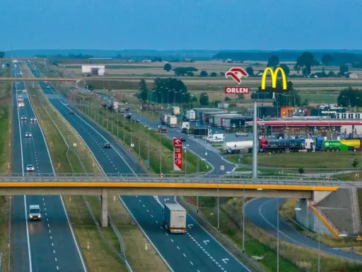 Droga ekspresowa z ruchem samochodów i ciężarówek, przy której znajduje się stacja Orlen i McDonald's. To idealne miejsce na krótki postój, czyli **mop skrót**.