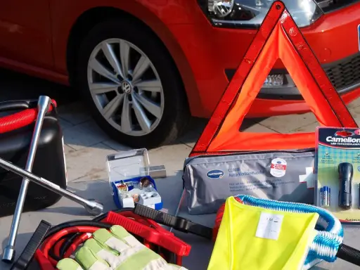 Gadżety przydatne w podróży: kanister, klucz, apteczka, trójkąt ostrzegawczy, latarka, kamizelka odblaskowa i kable rozruchowe.