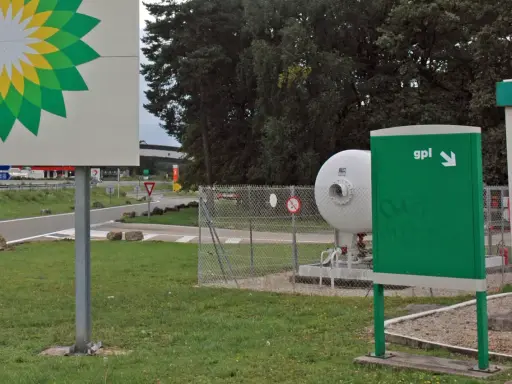 Stacja paliw z logo BP i dystrybutorem LPG. Widoczny zbiornik na gaz i znak "gpl" wskazujący kierunek. Ceny LPG w Europie mogą się różnić.