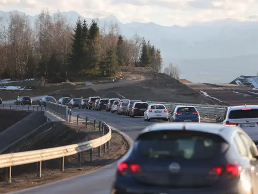 Korek na sieradz trasa. Samochody stoją w długiej kolejce na drodze z widokiem na góry i las.