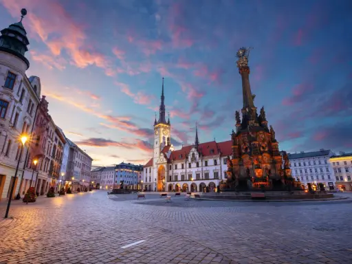 Rynek w Ołomuńcu, perle Moraw Południowych, o zachodzie słońca. Majestatyczna kolumna Trójcy Świętej i ratusz w blasku lamp.