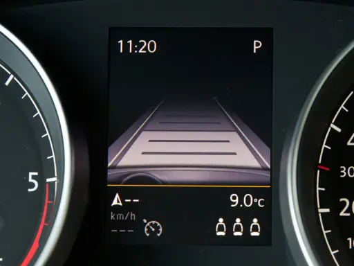 Wyświetlacz w samochodzie pokazuje widok drogi, zegar 11:20 i temperaturę 9°C. To pomocne informacje, gdy zastanawiasz się, tempomat co to jest i jak działa.