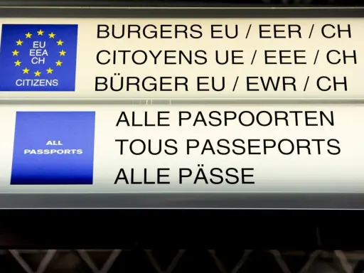 Znaki informacyjne na lotnisku: "Obywatele UE/EOG/CH" i "Wszystkie paszporty". Strefa Schengen-lista państw.