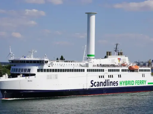 Prom na trasie Rostock-Gedser, "Berlin", z charakterystycznym, wysokim kominem i zielonym napisem "Scandlines HYBRID FERRY", płynie po wodzie.