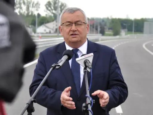 Mężczyzna w garniturze przemawia do mikrofonów na tle nowej drogi, która połączy Lublin i Rzeszów.
