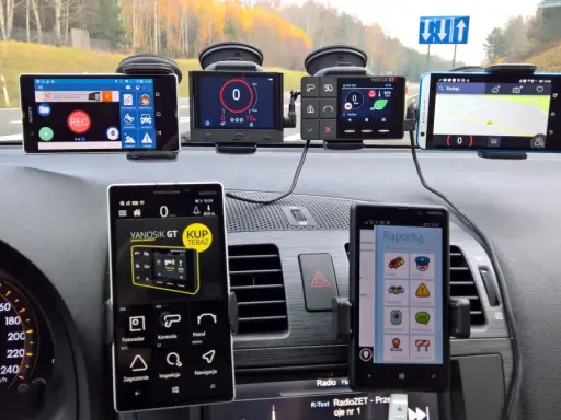 Na desce rozdzielczej samochodu zamontowano kilka urządzeń nawigacyjnych i telefonów, które pomagają w podróży. Widać prędkościomierz i mapę. Ta piła trasa była dobrze przygotowana.