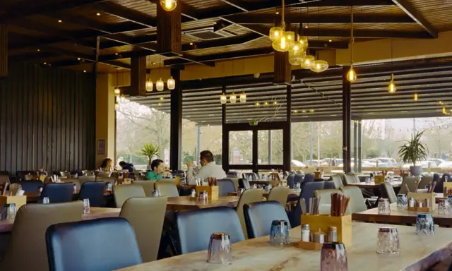 Przytulna restauracja z drewnianymi elementami i designerskimi lampami. Idealne miejsce na dobre jedzenie na trasie Kraków-Zakopane.