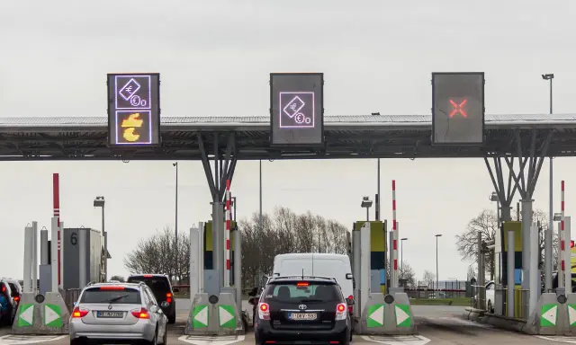 Korki na bramkach na autostradzie. Znaki pokazują symbole euro i przekreślone na czerwono pole.