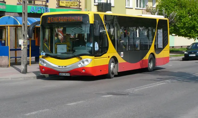 Żółto-czerwony autobus miejski z napisem "2 ENERGOMONTAŻ" na trasie w Sochaczewie.