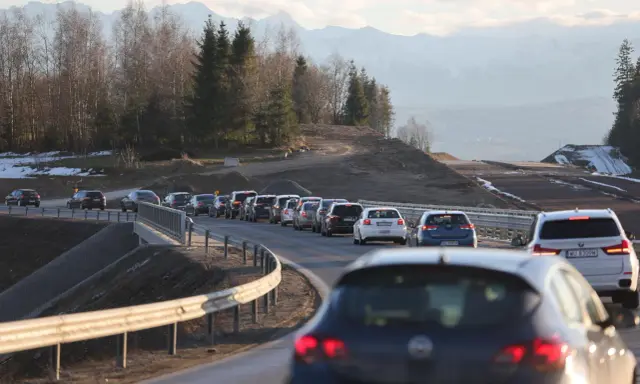 Korek na sieradz trasa. Samochody stoją w długiej kolejce na drodze z widokiem na góry i las.