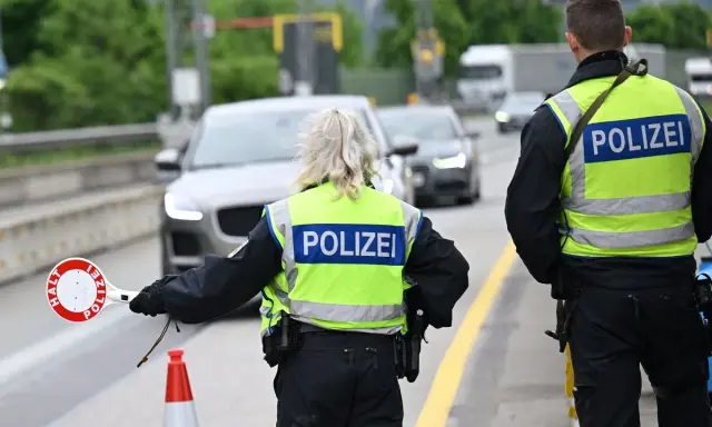 Policjanci kierują ruchem na trasie w Zgorzelcu. Jeden z nich trzyma znak "STOP".