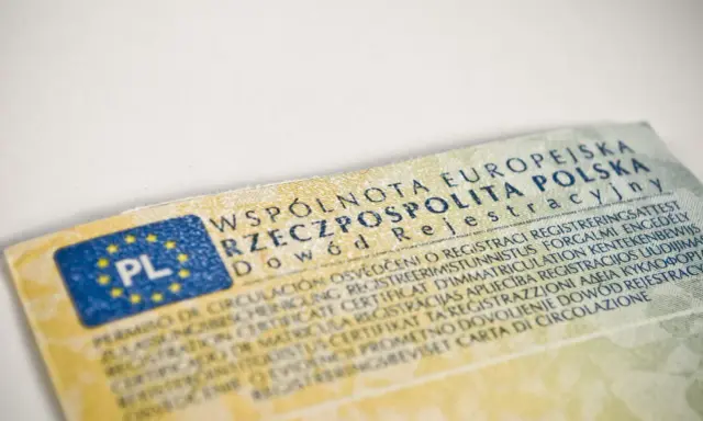 Dowód rejestracyjny pojazdu, niezbędny do ubezpieczenia auta, z flagą PL i tekstem w wielu językach.