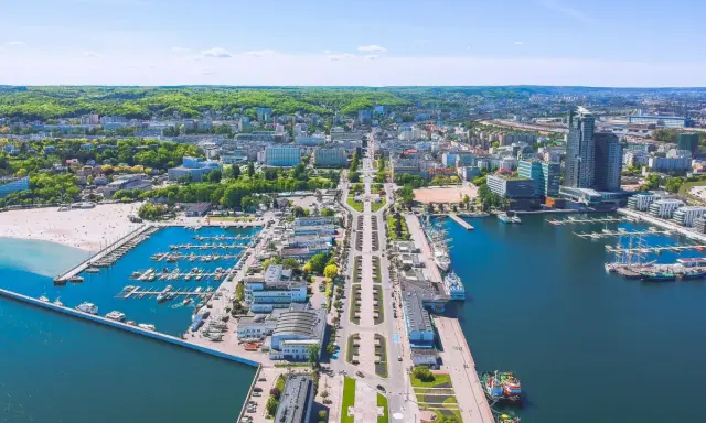 Widok na Gdynię z lotu ptaka. Widać port jachtowy, plażę i zabudowę miejską. Odległość do Wejherowa jest spora, ale widok zapiera dech.