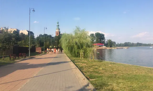 Spacer po chełmno trasa nad jeziorem. W oddali widać wieżę kościelną i zabudowania.