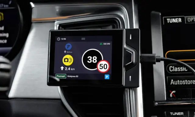 Nawigacja w pojeździe kategorii M1 pokazuje aktualną prędkość 38 km/h i ograniczenie do 50 km/h.