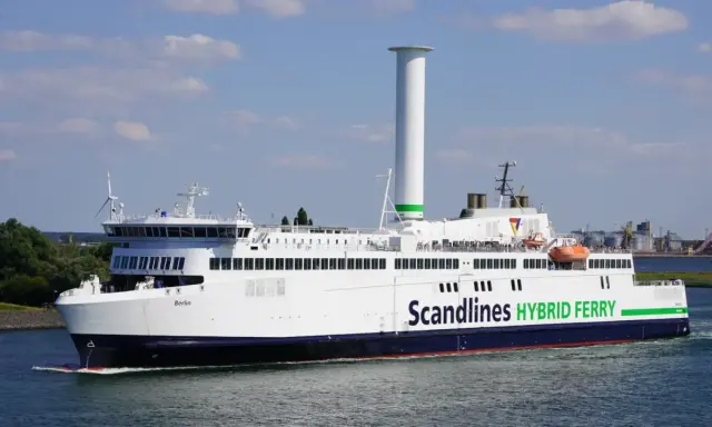 Prom na trasie Rostock-Gedser, "Berlin", z charakterystycznym, wysokim kominem i zielonym napisem "Scandlines HYBRID FERRY", płynie po wodzie.