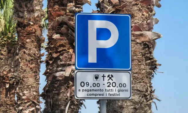 Znaki drogowe we Włoszech: niebieski znak parkingu z literą "P" i tabliczka informująca o płatnym parkingu od 9:00 do 20:00, codziennie, w tym święta.