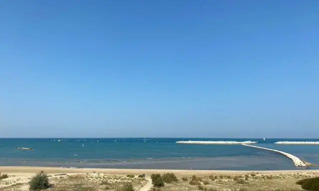 Piękny dzień nad morzem w Pescara i okolice. Wiele żaglówek na turkusowej wodzie, piaszczysta plaża i falochrony.