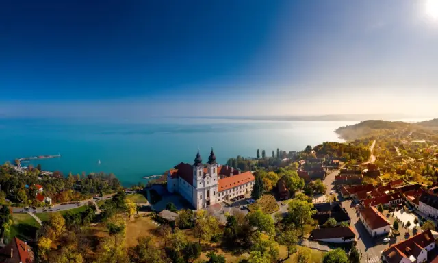 Opactwo na półwyspie Tihany nad Balatonem na Węgrzech, otoczone jesiennymi drzewami i malowniczą wioską.