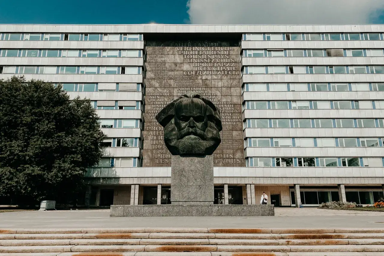 Pomnik Karola Marksa w Chemnitz, jedna z głównych atrakcji miasta, na tle modernistycznego budynku.