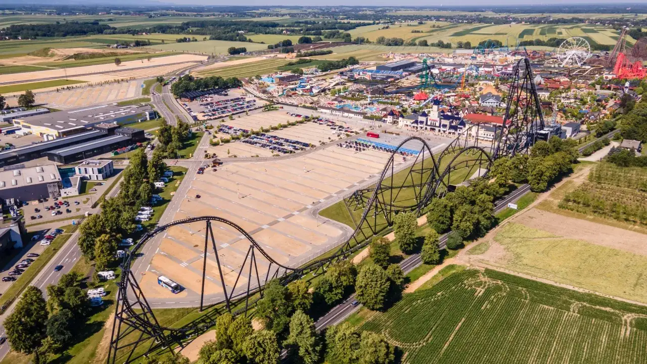 Zator Energylandia trasa kolejki górskiej przecina krajobraz, prowadząc do parku rozrywki z licznymi atrakcjami.