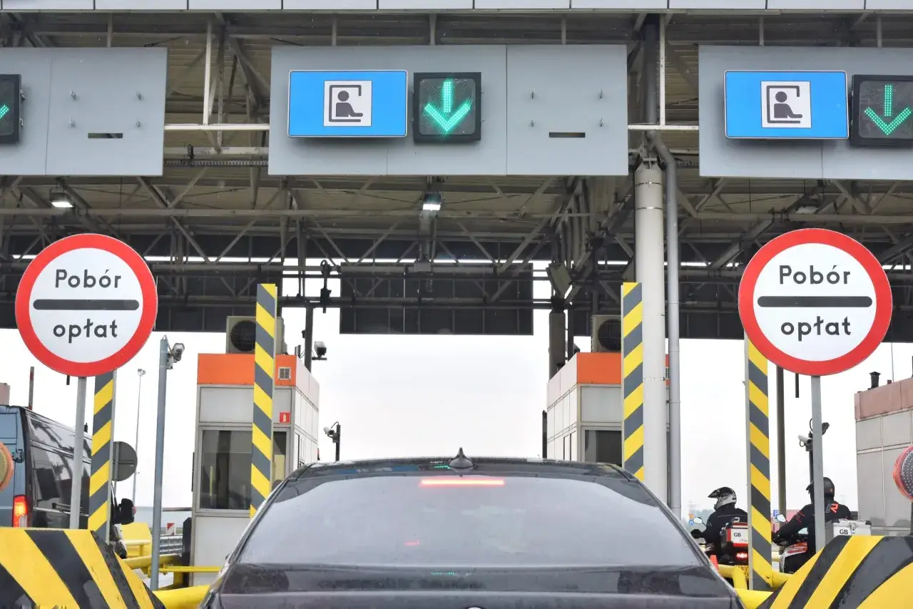 Kolejka do punktu poboru opłat. Zielone strzałki wskazują, jak działa autopay, umożliwiając szybki przejazd.