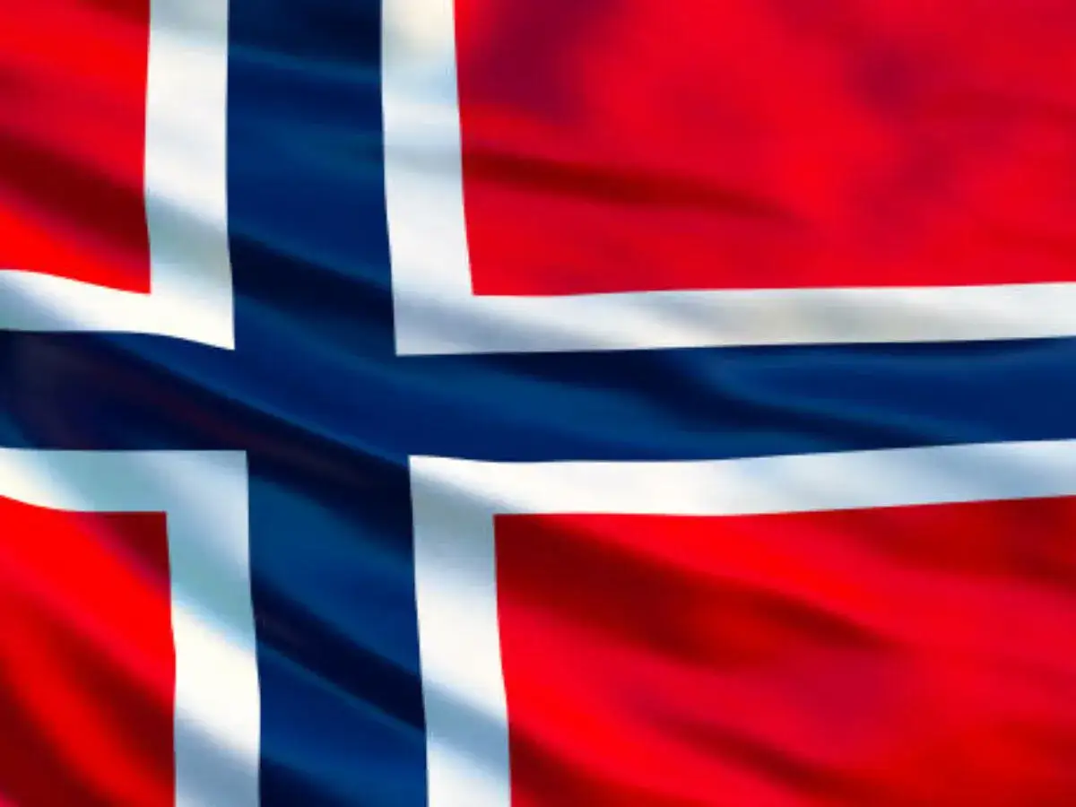 Flaga Norwegii. Planujesz podróż i zastanawiasz się, czy w Norwegii można płacić euro? Odpowiedź brzmi: nie, Norwegia nie należy do strefy euro.