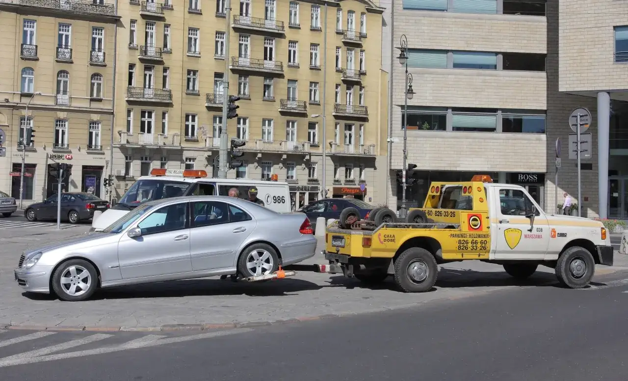 Srebrny Mercedes jest holowany przez żółtą ciężarówkę. Pytanie: czy można holować automat? Odpowiedź: tak, jeśli jest to robione prawidłowo.